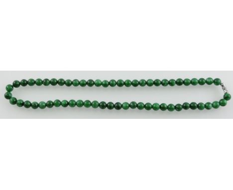 A jade necklace, of uniform beads, L. 44cm.