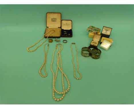 A collection of vintage jewellery boxes including Bristol, faux pearls, three hallmarked silver napkin rings and three charms