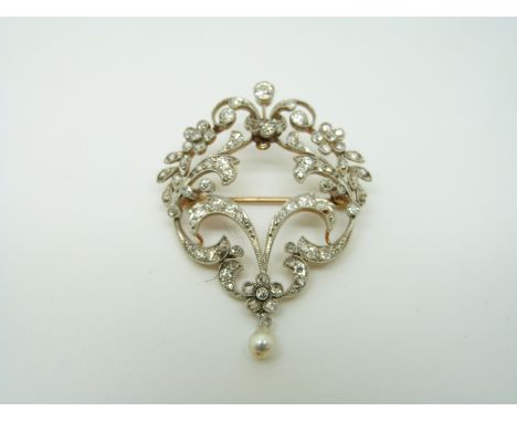An early 20thC brooch set with diamonds in a floral/ foliate design and a drop pearl, 4.2 x 3.6cm
