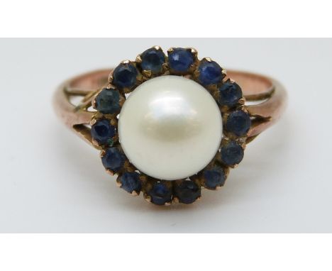 A 9ct gold ring set with a pearl surrounded by sapphires (size K) 