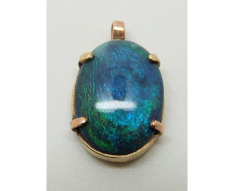 A 9ct gold pendant set with a black opal cabochon, 2.2cm