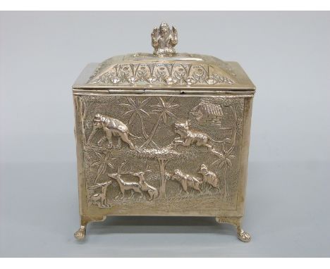An Indian/Burmese white metal tea caddy with relief decoration of wild animals including elephants, lions etc in a jungle set