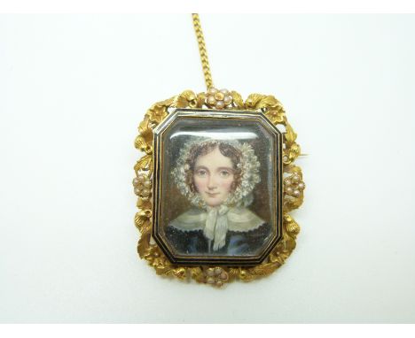 A Victorian mourning brooch set with a portrait miniature of a young woman, within a foliate border set with seed pearls, ver
