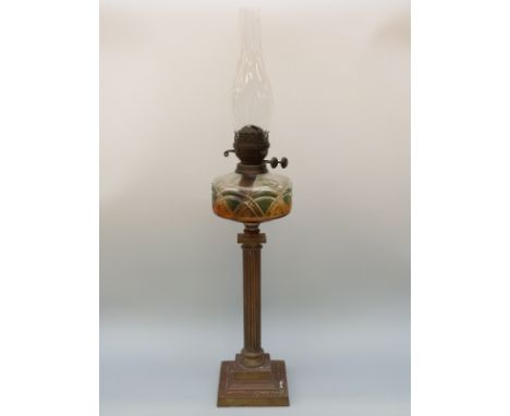 A Victorian cut glass oil lamp with amber and green cut glass reservoir and twin Duplex burner raised on a brass Corinthiam c