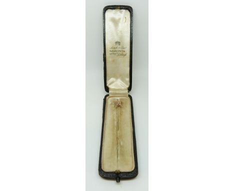 A yellow metal and pearl pin