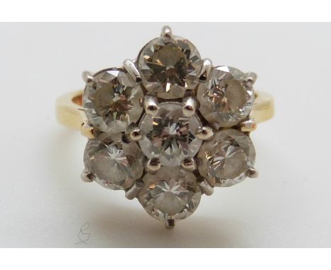 An 18ct gold ring set with seven round brilliant cut diamonds in a cluster, the centre diamond approximately 0.55ct, total di