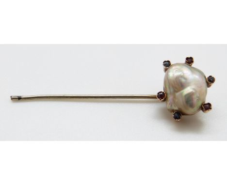 A stick pin set with a baroque pearl approximately 1.5 x 1.1cm surrounded by rubies and sapphires, 5cm length