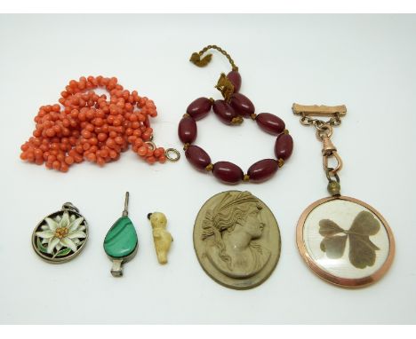 A silver fob in the form of bellows set with malachite, a silver pendant set with enamel in the form of a flower, a Victorian