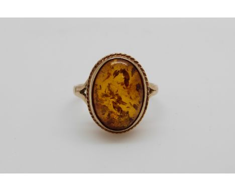 A 9ct gold ring set with pressed amber (size K)