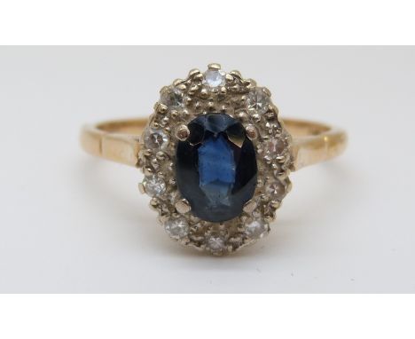 An 18ct gold ring set with an oval sapphire, surrounded by diamonds (size R) 