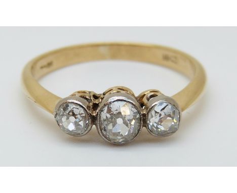 An 18ct gold ring set with three old cut diamonds in a platinum setting, the largest approximately 0.35ct (size K)