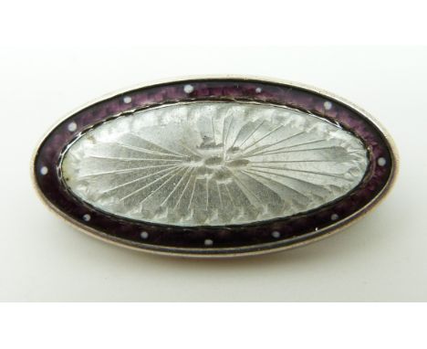 A silver brooch set with enamel