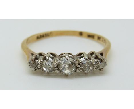 An 18ct gold ring set with five old cut diamonds in a platinum setting, the largest diamond approximately 0.2ct (size O) 