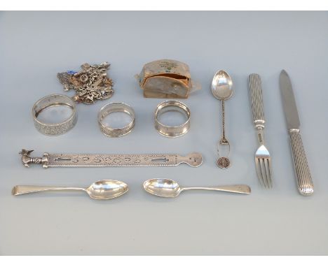 A hallmarked silver and white metal charm bracelet, hallmarked silver spoon and three silver napkin rings, weight 148g all in