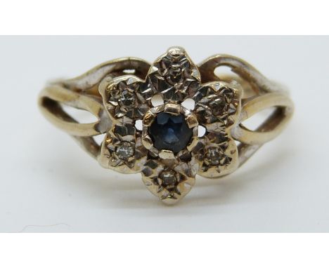 A 9ct gold ring set with a sapphire surrounded by diamonds in a cluster (size K) 