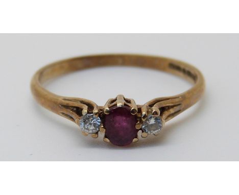 A 9ct gold ring set with an oval cut ruby and two diamonds (size M)