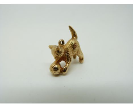 A 9ct gold charm/ pendant in the form of a cat playing with a ball, 6.6g