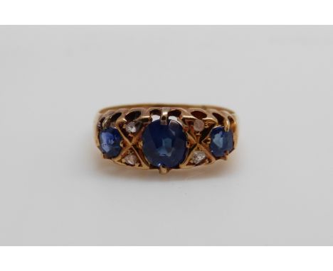 An 18ct gold ring set with three oval cut sapphires and four diamonds (size K/L)