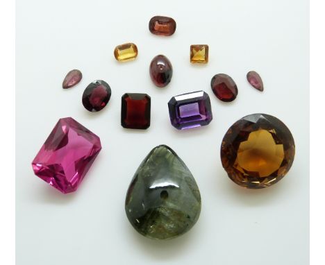 A collection of gemstones including a mixed cut synthetic ruby, an emerald cut purple sapphire, two oval garnets, an emerald 