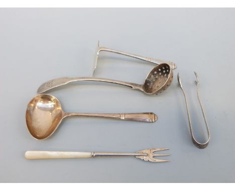 A Georgian silver sifter spoon, silver pusher, silver spoon and silver tongs, weight 72g, and a silver and mother of pearl pi