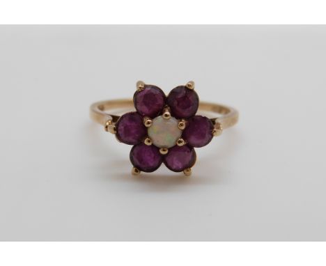 A 9ct gold ring set with an opal surrounded by rubies, 2.3g, size O