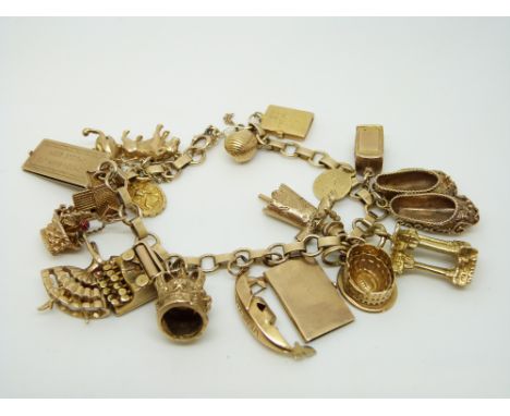 A 9ct gold charm bracelet with a large quantity of 9ct gold charms including cheque book, driving license, typewriter, shoes,