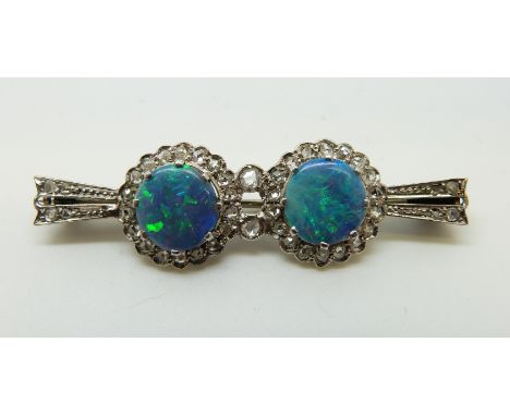 An Art Deco 9ct white gold brooch set with two opal doublets surrounded by rose cut diamonds, 4.9cm, 4.8g