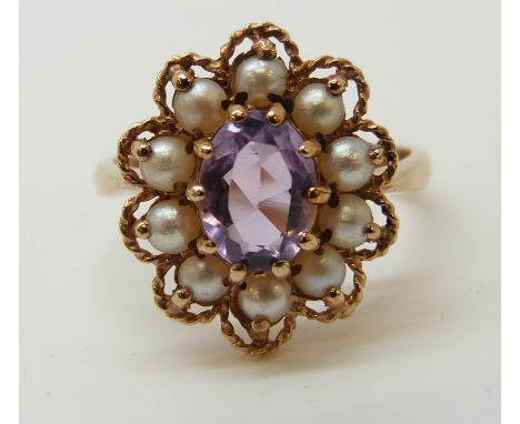 A 9ct gold ring set with an amethyst and surrounded with pearls (size N) 