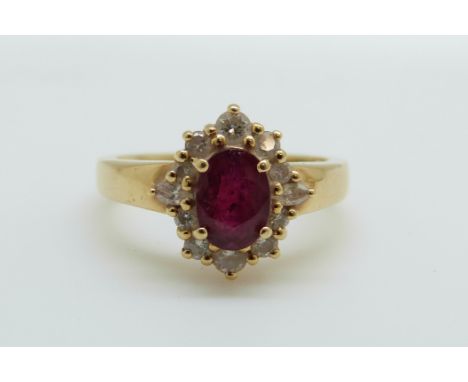 An 18ct gold ring set with an oval cut ruby of approximately 0.75ct surround by diamonds, 4.4g, size L