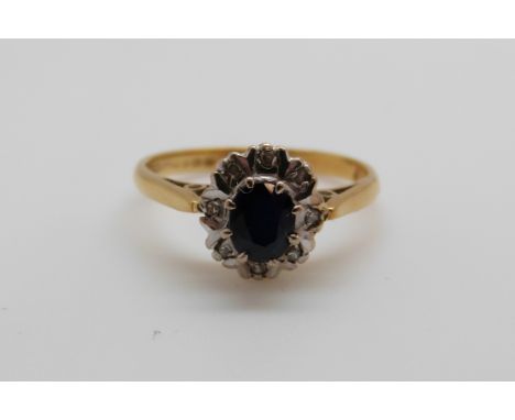 An 18ct gold ring set with a sapphire surrounded by diamonds (size K) 