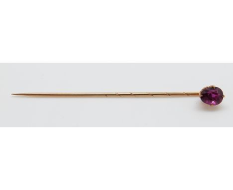 A yellow metal stick pin set with an oval ruby measuring approx 1ct, 7cm 