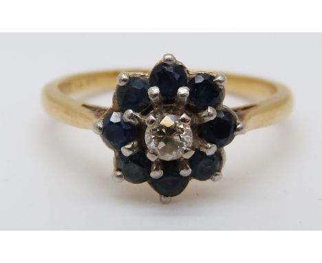 An 18ct gold ring set with a diamond surrounded by sapphires (size K) 