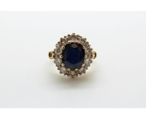 An 18ct gold rings set with a sapphire of approximately 2.35ct surrounded by diamonds, each approximately 0.1ct (size K/L)