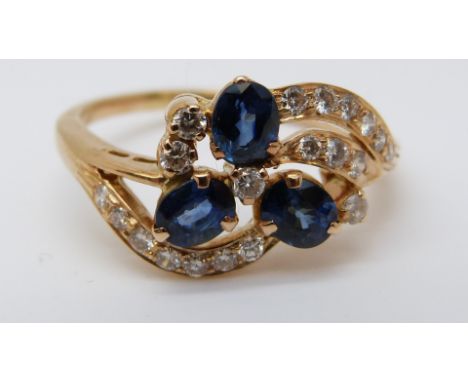 An 18ct gold ring set with three sapphires and diamonds in a floral setting (size R) 