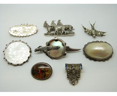 An Edwardian silver brooch with bird and foliate design, a Victorian swallow brooch, three mother of pearl brooches and a goa