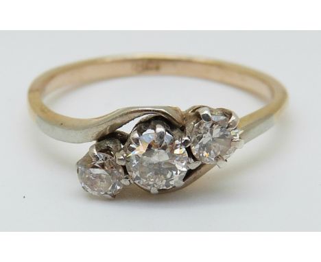 An 18ct gold ring set with three diamonds in a twist setting, the largest diamond approximately 0.25ct, 2.06g (size L)