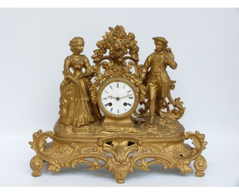 A 19thC ormolu figural clock, the drum case with male and female figure either side in 18thC costume, the girl holding a smal