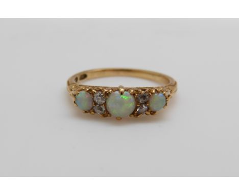 An 18ct gold ring set with three opal cabochons and four old cut diamonds (size N)