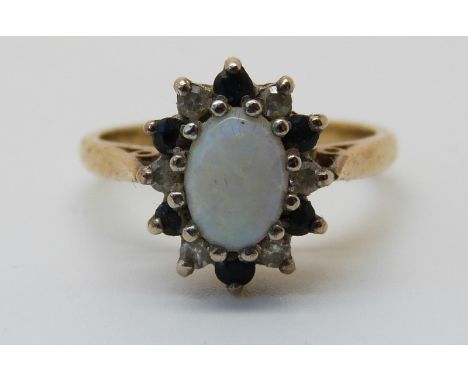 A 18ct gold ring set with an opal surrounded by diamonds and sapphires (size J) 