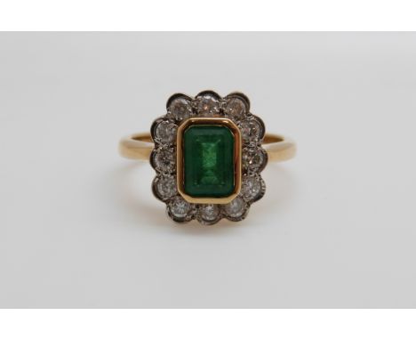 An 18ct gold ring set with an emerald cut emerald of approximately 1ct surround by diamonds (size N/O) 