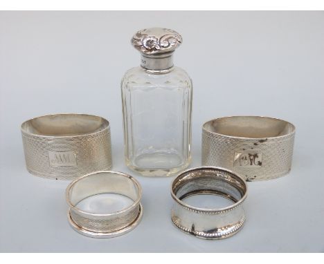 A pair of oval hallmarked silver engine turned napkin rings and two further napkin rings, weight 87g, and a hallmarked silver