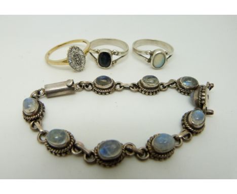 Three silver rings, one set with an opal, one diamonds and the other a sapphire together with a silver bracelet set with moon