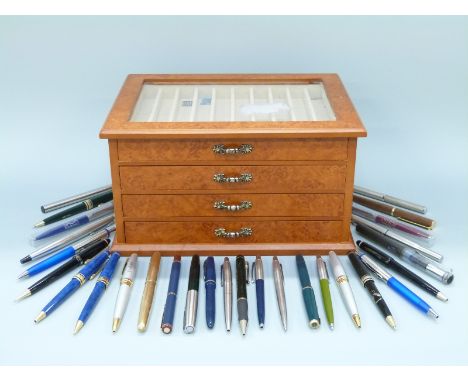 A pen collector's cabinet with four fitted drawers containing a collection of pens including several Parker models including 