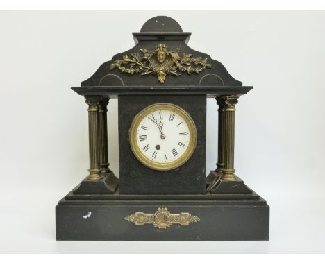 A Victorian slate mantel clock with Romanesque architectural case, supported by four reeded columns with acanthus leaf capito