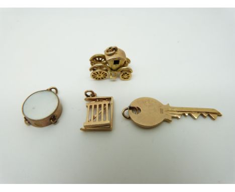 Four 9ct gold charms, key, drum, gate and a coronation coach, 7.9g