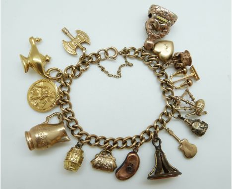 A 9ct gold charm bracelet with eleven 9ct gold charms including a crown, St Christopher, purse, cello, scales etc, 40.6g