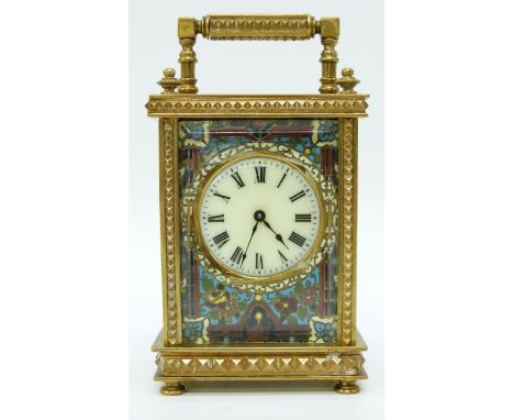 A circa early 20thC brass cased carriage clock, the ivory coloured enamelled Roman dial set in champlevé surround the brass c