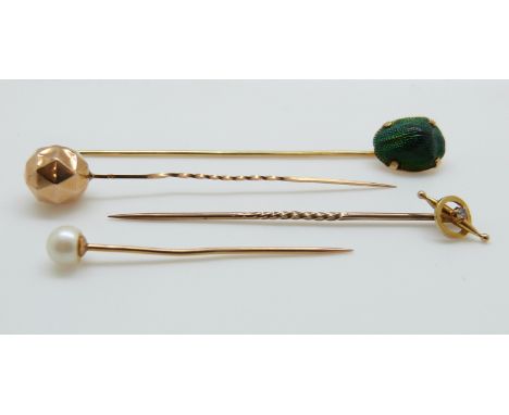 A Victorian stick pin set with a scarab beetle, a Victorian gold stick pin set set with a faceted sphere, a pearl set stick p