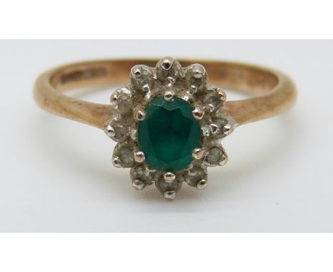 A 9ct gold ring set with an apple green oval emerald surrounded by diamonds (size K) 