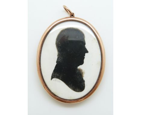 A 19thC yellow metal double-sided mourning silhouette, the reverse with a mounted lock of hair wrapped with braided yellow me
